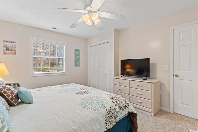 carpeted bedroom featuring ceiling fan, a textured ceiling, and a closet