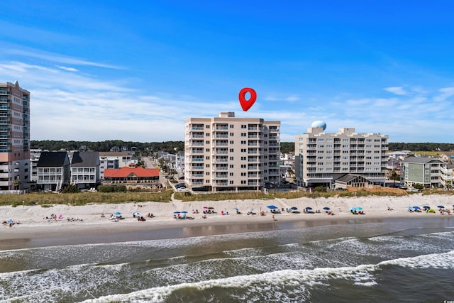 view of building exterior featuring a beach view and a water view