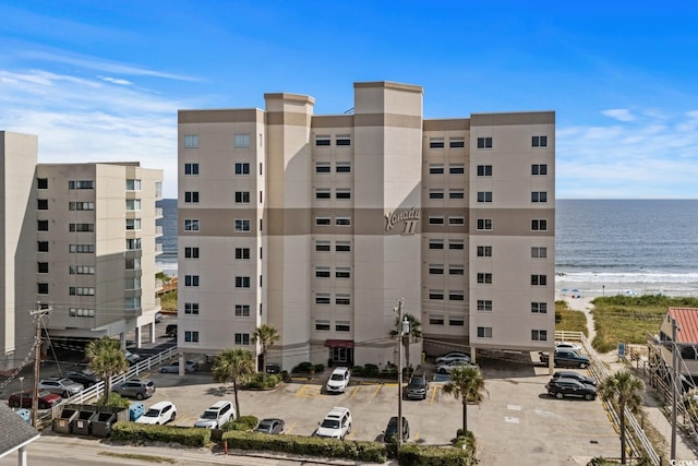 view of building exterior featuring a beach view and a water view