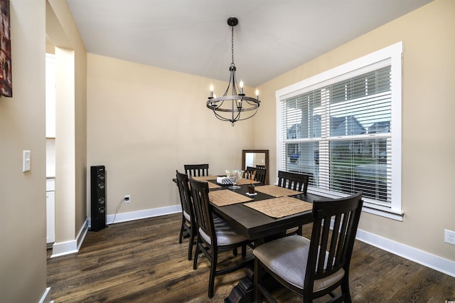 dining area featuring dark wood-type flooring and a chandelier