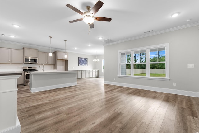 kitchen with hanging light fixtures, a kitchen island with sink, hardwood / wood-style flooring, stainless steel appliances, and ceiling fan with notable chandelier