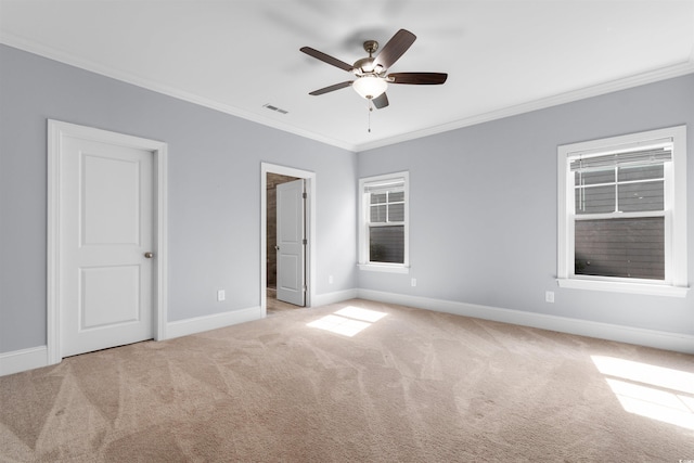 unfurnished bedroom featuring ceiling fan, light colored carpet, and crown molding