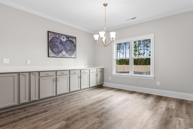 interior space with crown molding, hardwood / wood-style floors, and a notable chandelier