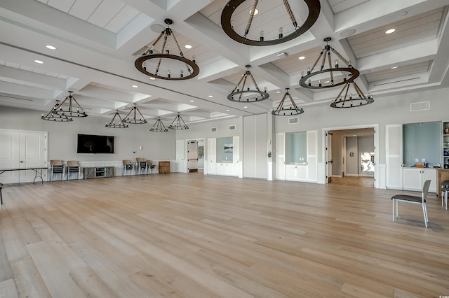 unfurnished living room with beam ceiling, a towering ceiling, coffered ceiling, and light wood-type flooring