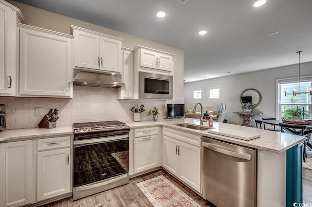 kitchen featuring stainless steel appliances, white cabinetry, a wealth of natural light, and sink