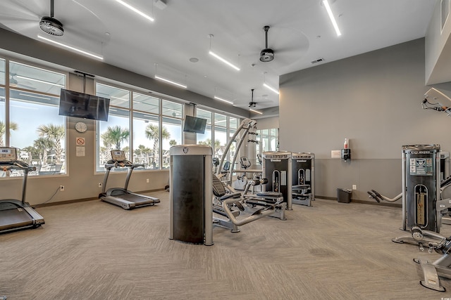 workout area with ceiling fan and light carpet