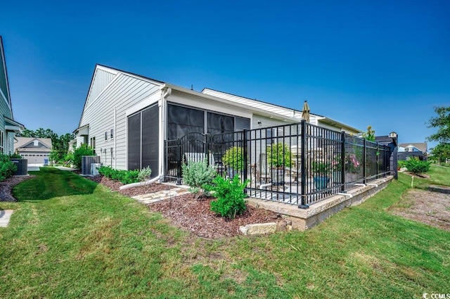 back of house featuring a sunroom, a yard, and cooling unit