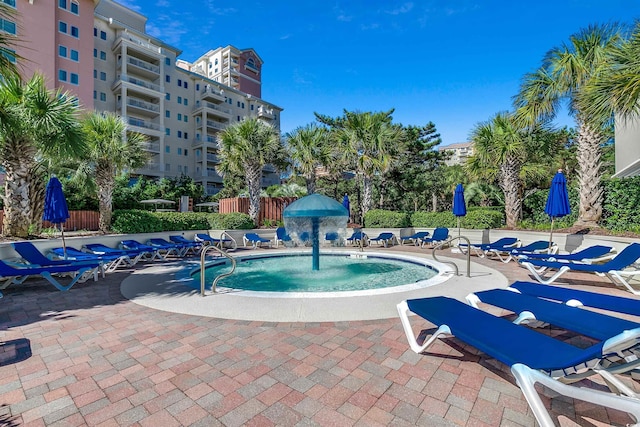 view of swimming pool with pool water feature and a patio area