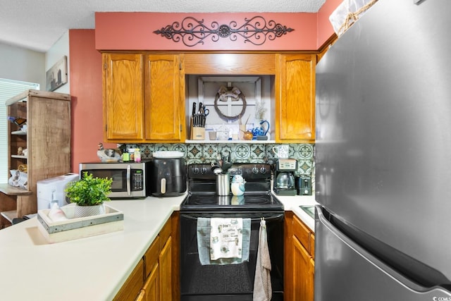 kitchen with decorative backsplash, a textured ceiling, and appliances with stainless steel finishes