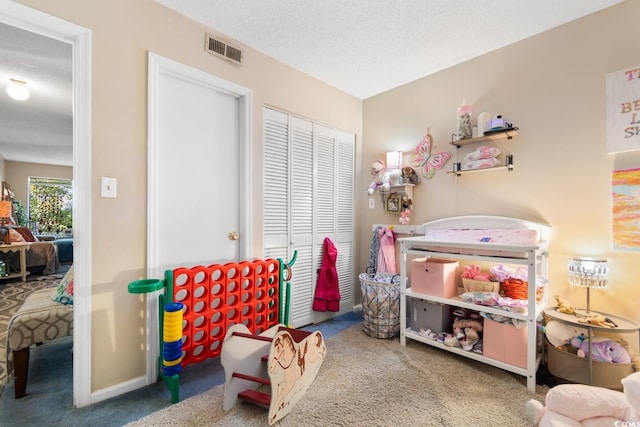 recreation room with carpet and a textured ceiling