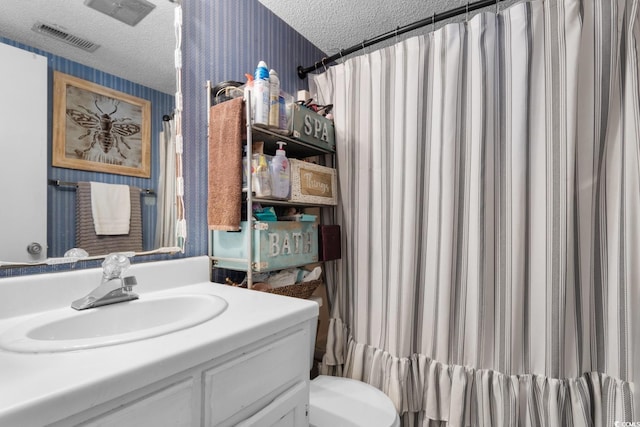 bathroom with vanity, a textured ceiling, and toilet