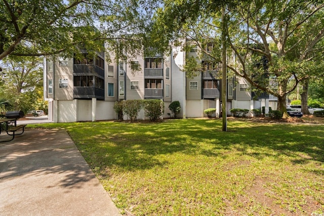 view of front facade featuring a balcony and a front lawn