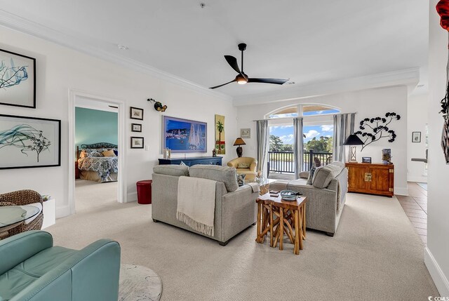 living room with ceiling fan, light colored carpet, and crown molding