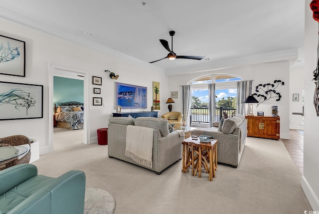 carpeted living room with baseboards, a ceiling fan, and ornamental molding