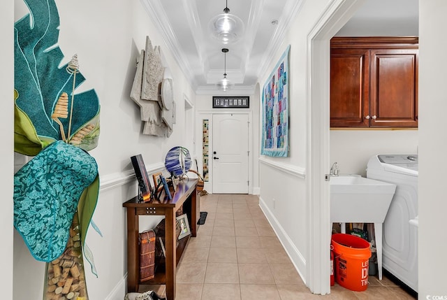 washroom with ornamental molding, washer / clothes dryer, cabinet space, light tile patterned flooring, and baseboards