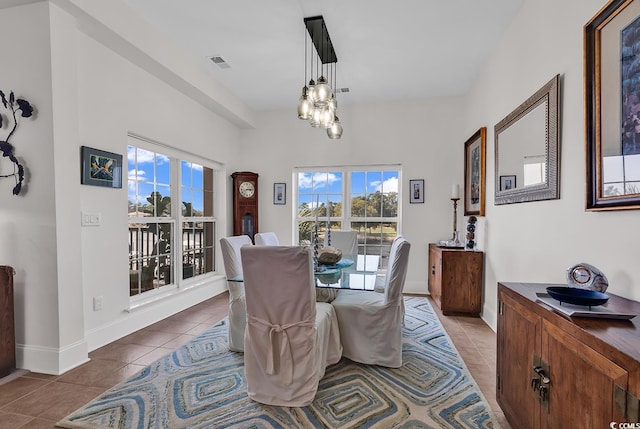 tiled dining room with visible vents, an inviting chandelier, and baseboards