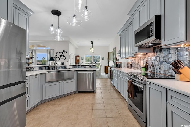 kitchen with light tile patterned floors, gray cabinets, a sink, stainless steel appliances, and light countertops