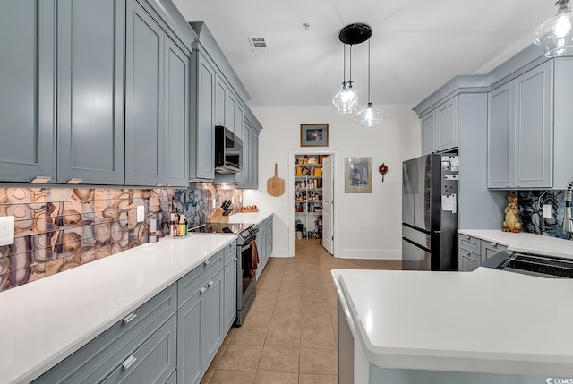 kitchen with visible vents, range with electric cooktop, gray cabinetry, stainless steel microwave, and freestanding refrigerator