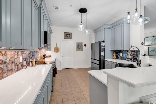 kitchen featuring stainless steel appliances, gray cabinetry, light tile patterned flooring, and light countertops