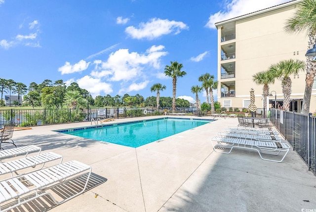 pool with a patio and fence