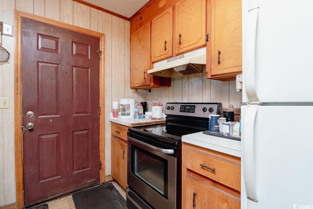 kitchen with wooden walls, stainless steel electric range oven, and white refrigerator