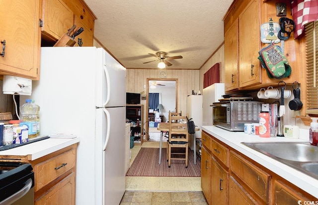 kitchen featuring ceiling fan, stainless steel range oven, sink, and a textured ceiling