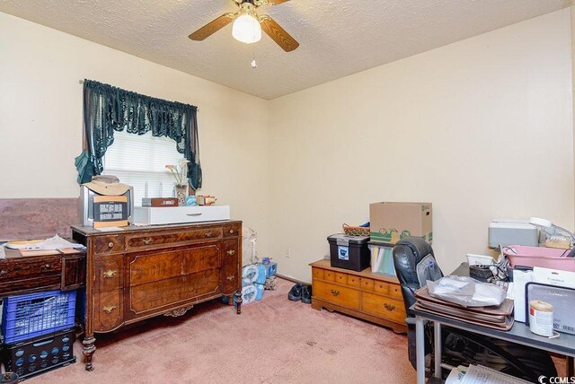 office area with ceiling fan, a textured ceiling, and carpet