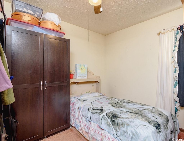 bedroom with light carpet, a textured ceiling, and ceiling fan