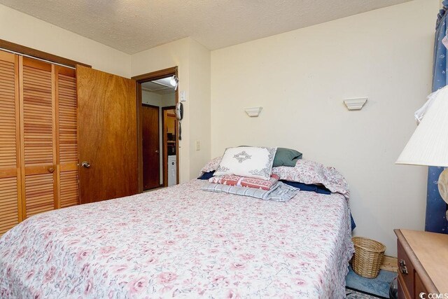 carpeted bedroom featuring a closet and a textured ceiling