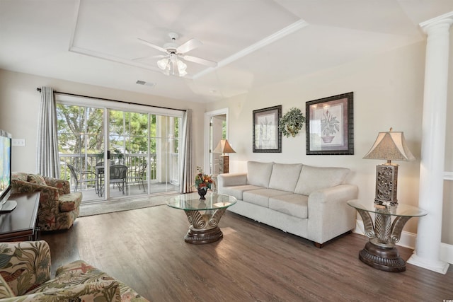 living room with ceiling fan, a tray ceiling, dark hardwood / wood-style flooring, and decorative columns