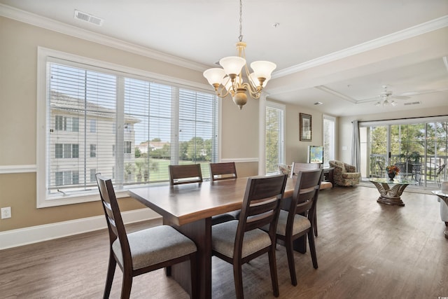 dining area featuring ceiling fan with notable chandelier, dark hardwood / wood-style floors, and crown molding