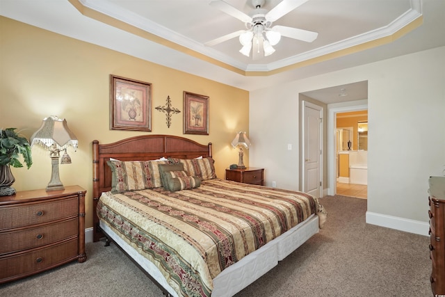 bedroom with a raised ceiling, carpet floors, ceiling fan, connected bathroom, and ornamental molding