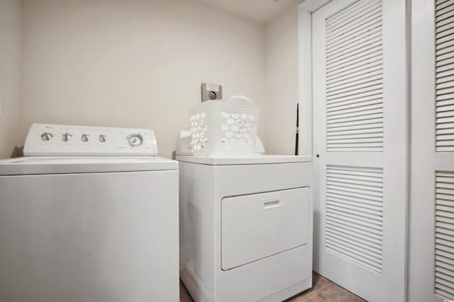 clothes washing area featuring washing machine and clothes dryer and light tile patterned flooring