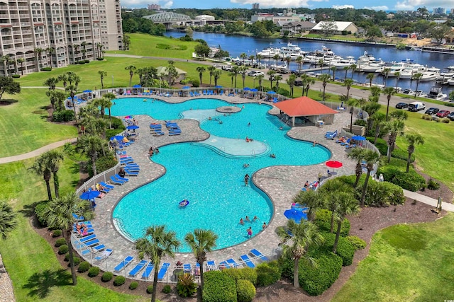 view of swimming pool with a water view, a yard, and a patio area