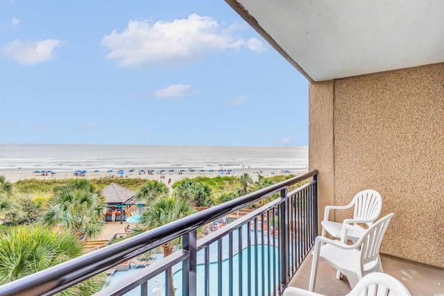 balcony featuring a water view and a beach view