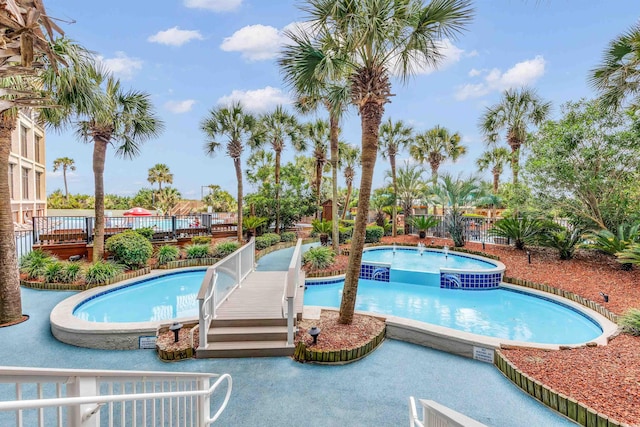 view of swimming pool featuring a hot tub