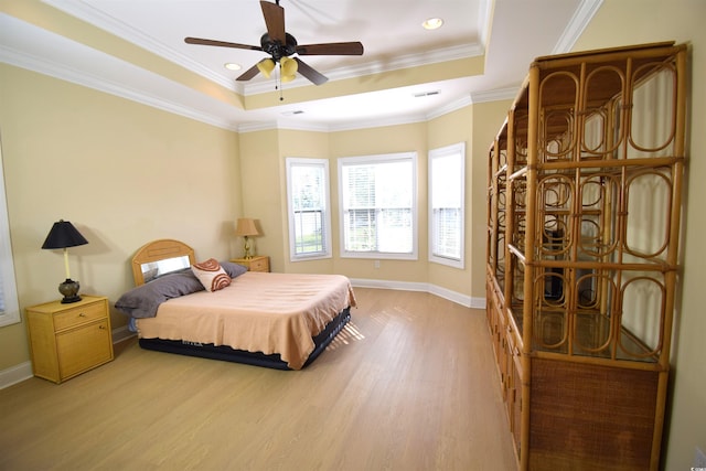 bedroom featuring ceiling fan, light hardwood / wood-style flooring, crown molding, and a raised ceiling