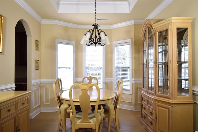 dining area with a raised ceiling, crown molding, dark hardwood / wood-style floors, and a chandelier