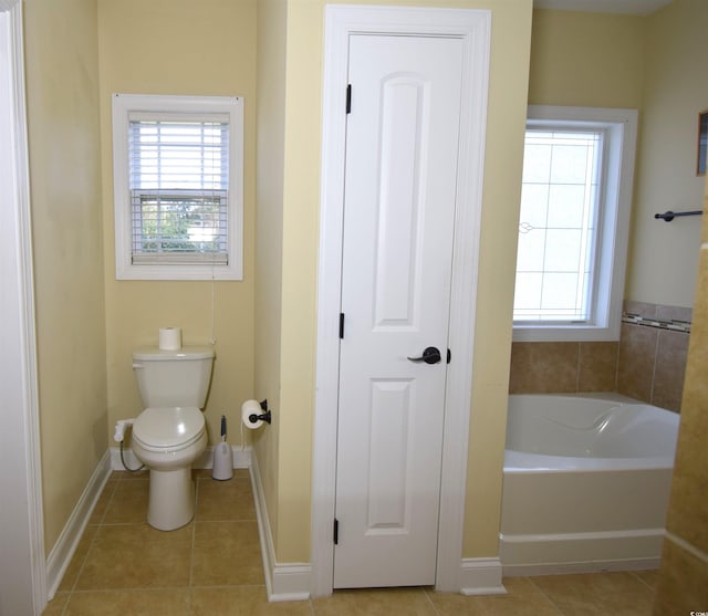 bathroom with tile patterned flooring, toilet, and a washtub