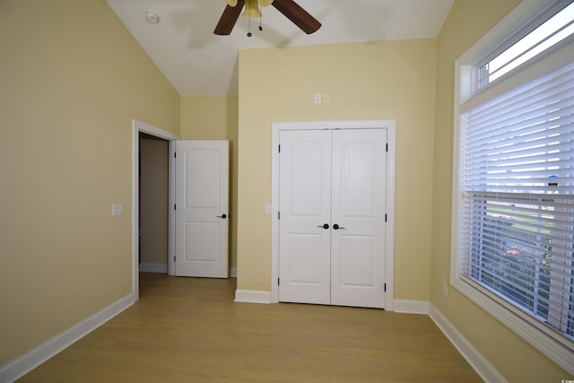 unfurnished bedroom featuring ceiling fan, light wood-type flooring, a closet, and multiple windows