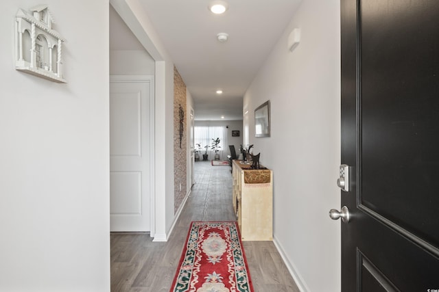 hallway with hardwood / wood-style flooring