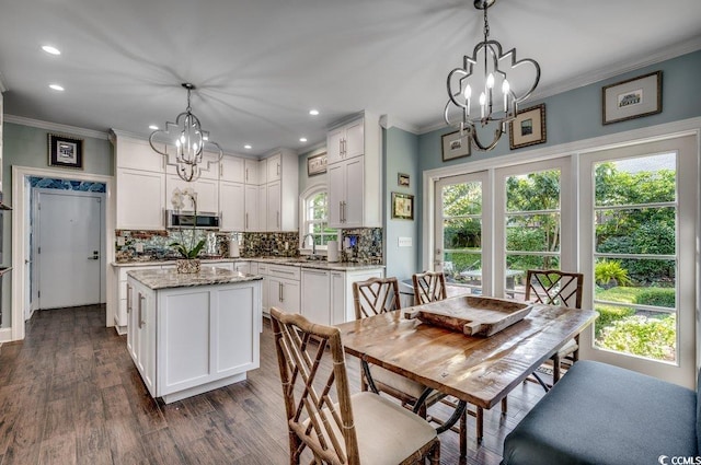 kitchen featuring decorative light fixtures, white cabinets, a center island, and dark hardwood / wood-style floors