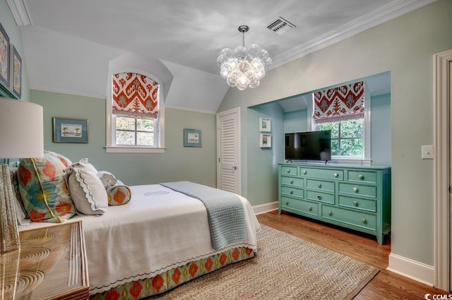 bedroom featuring ornamental molding, a notable chandelier, light wood-type flooring, and multiple windows