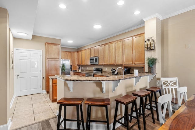 kitchen with ornamental molding, stainless steel appliances, light stone countertops, and kitchen peninsula