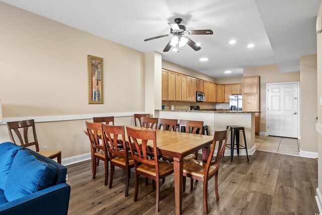 dining area with ceiling fan and light hardwood / wood-style flooring