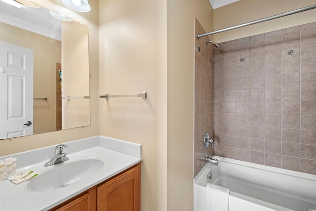 bathroom with crown molding, vanity, and tiled shower / bath combo