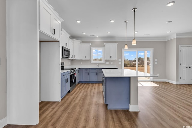 kitchen featuring light countertops, ornamental molding, a wealth of natural light, and stainless steel appliances