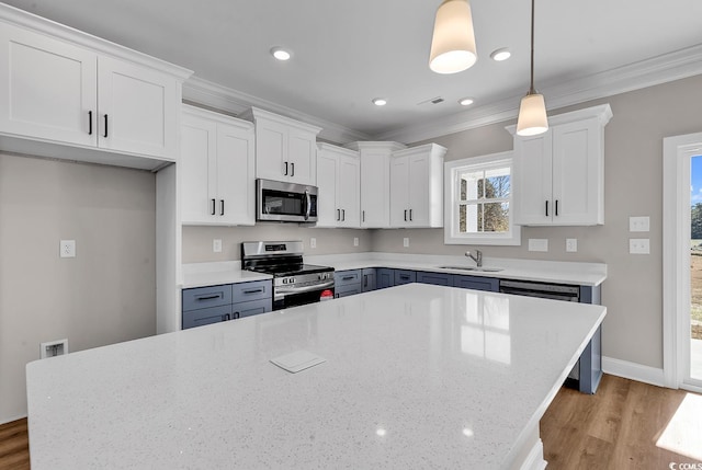 kitchen with appliances with stainless steel finishes, white cabinets, crown molding, and light wood finished floors