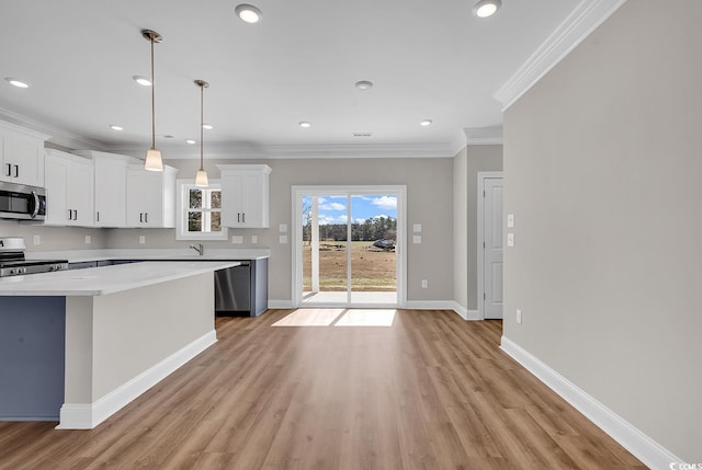 kitchen with light countertops, ornamental molding, baseboards, and stainless steel appliances