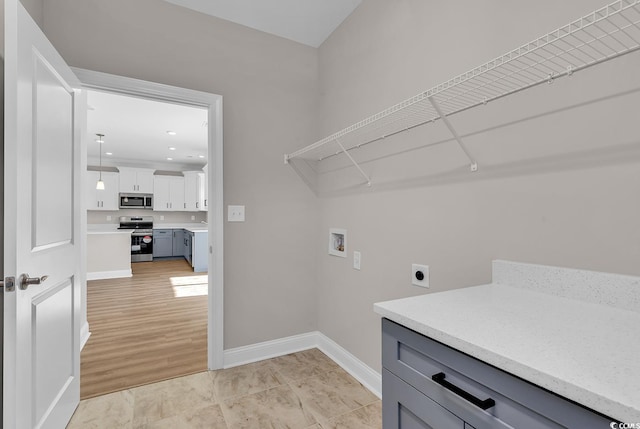 clothes washing area with washer hookup, light wood-style floors, baseboards, hookup for an electric dryer, and laundry area